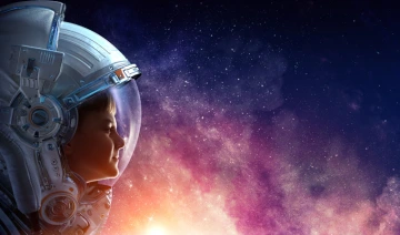 Image of child in spacesuit looking at galaxy